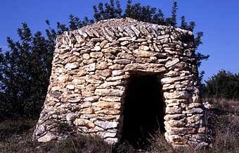 A Santa Oliva, com és usual a les comarques orientals, la pedra no està retocada. Son les típiques barraques. Aquesta és de planta circular i dimensions ajustades.