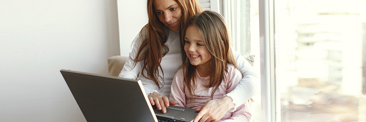 Mujer y niña en ordenador portatil