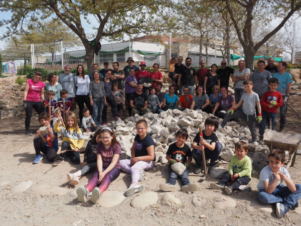 L'AFA del Maria Mercè Marçal construeix un mur de pedra seca al pati de l'escola amb la col·laboració de l'Associació d'Amics de l'Arquitectura Popular