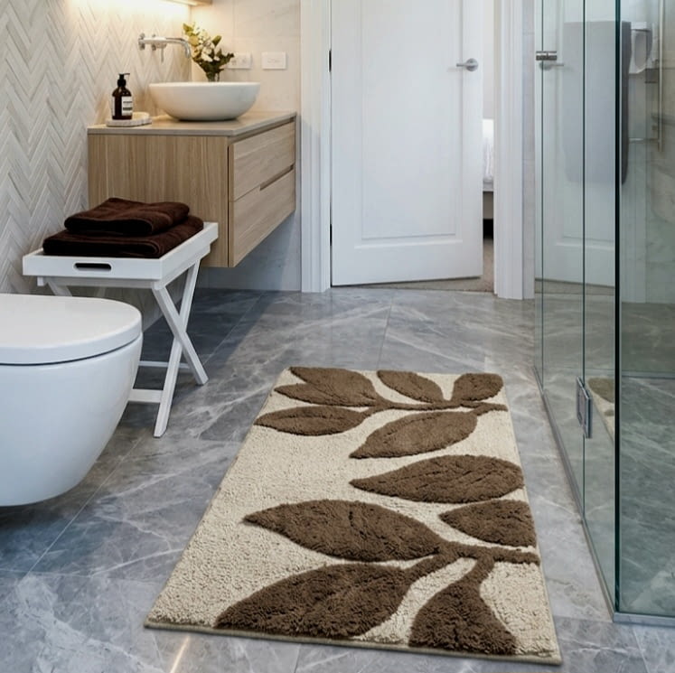 Alfombra de baño beige con hojas marrones