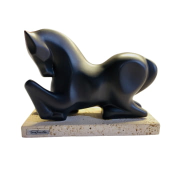 Escultura de caballo negro sobre mármol.