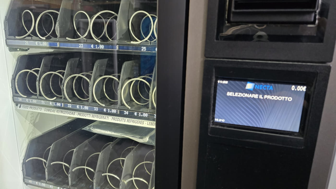 Una máquina expendedora que dispensa bocadillos y bebidas recién hechos Una máquina expendedora que dispensa bocadillos y bebidas recién hechos