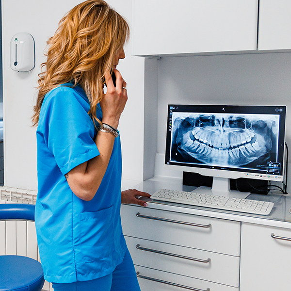 Dentista atendiendo a paciente por teléfono