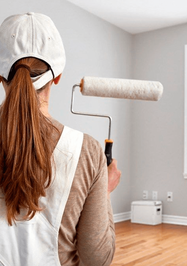 Mujer pintando casa