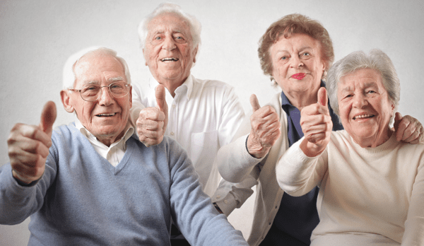 Gente mayor riendo saludando a la camara