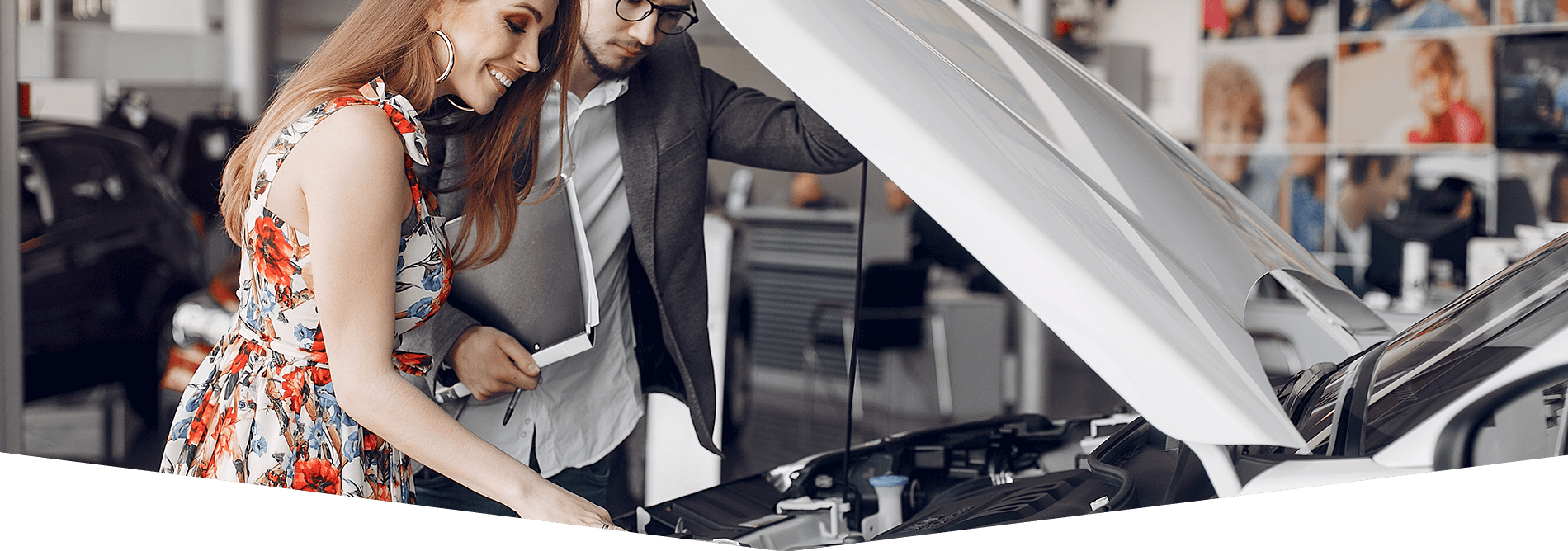 Cliente y comercial inspecionando motor coche