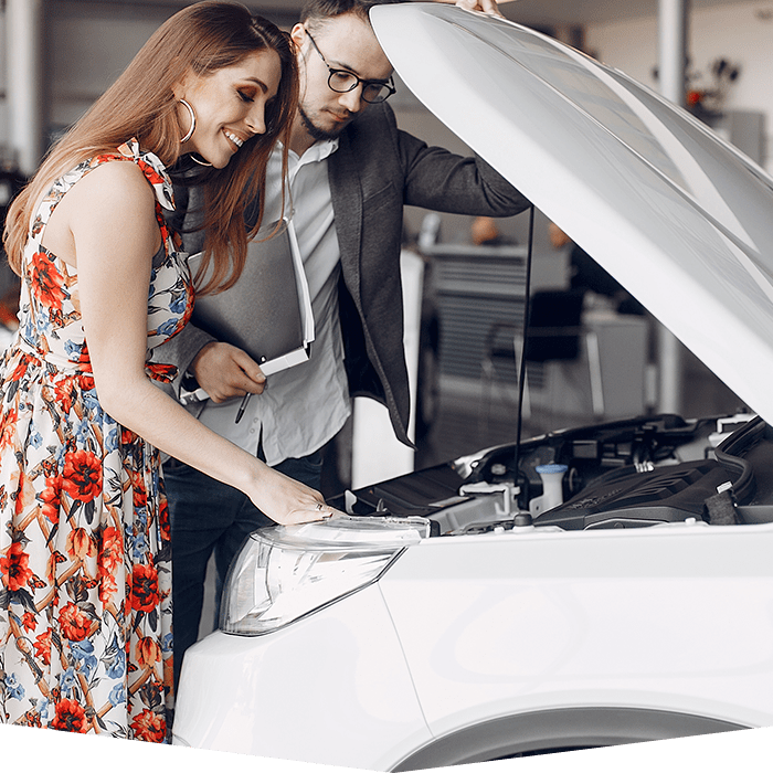 Cliente y comercial inspecionando motor coche