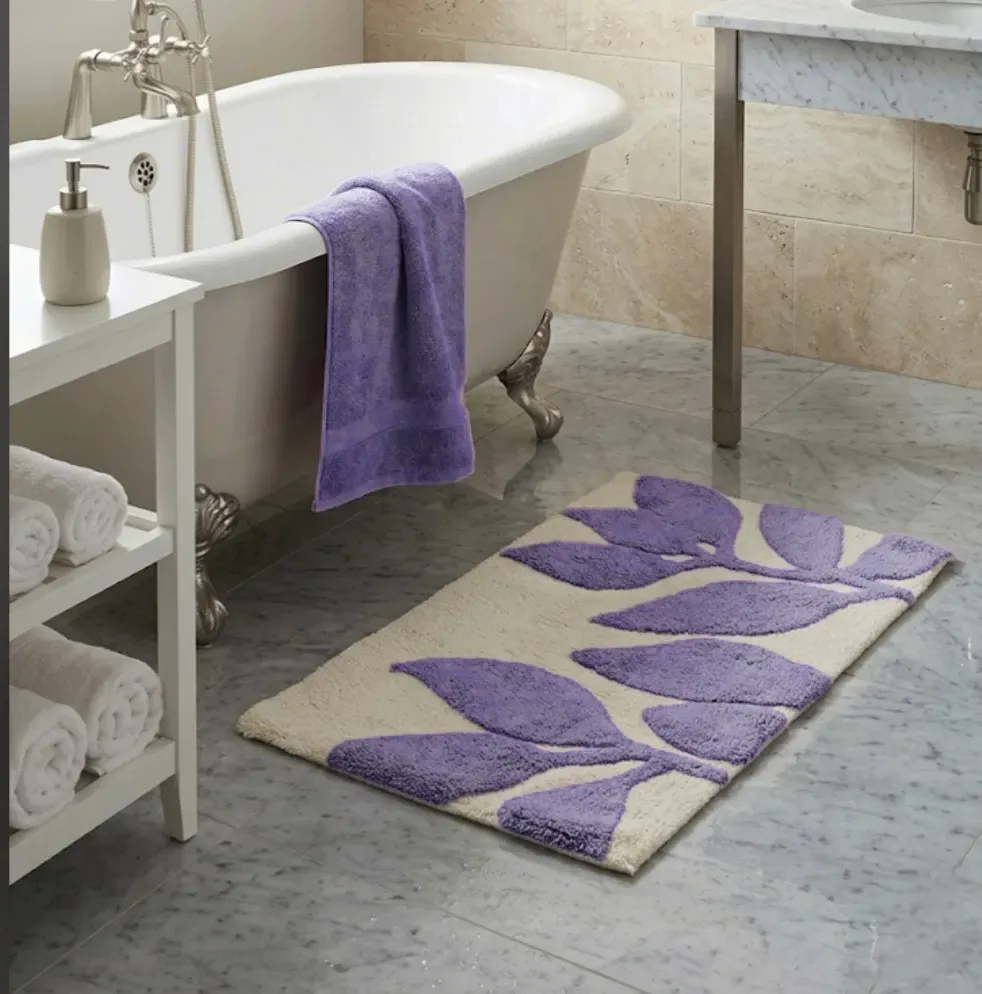 Alfombra de baño beige con hojas moradas