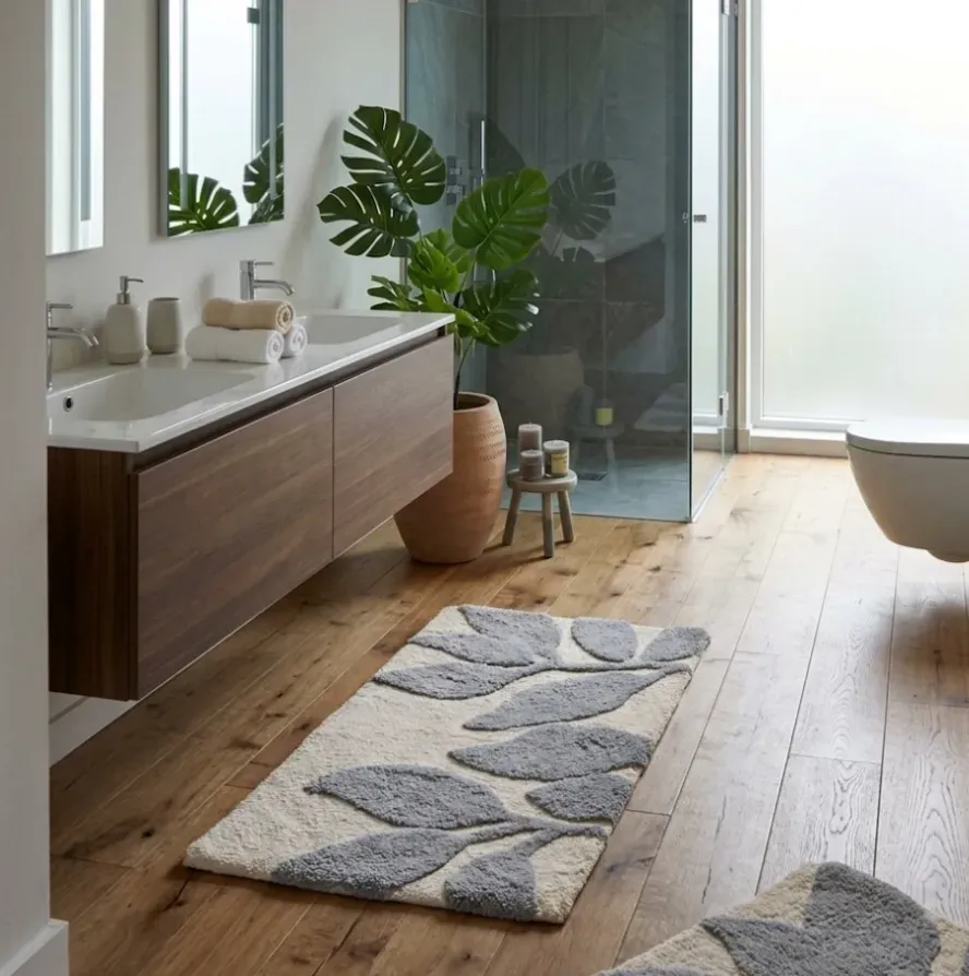 Alfombra de baño beige con hojas grises